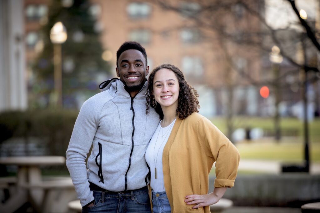 Une jolie photo d'un couple mis qui sourient et posent ensemble.